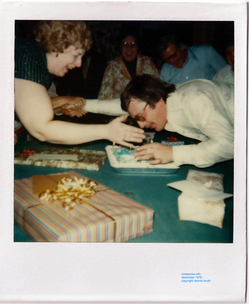 Dennis blows out the birthday cake candles