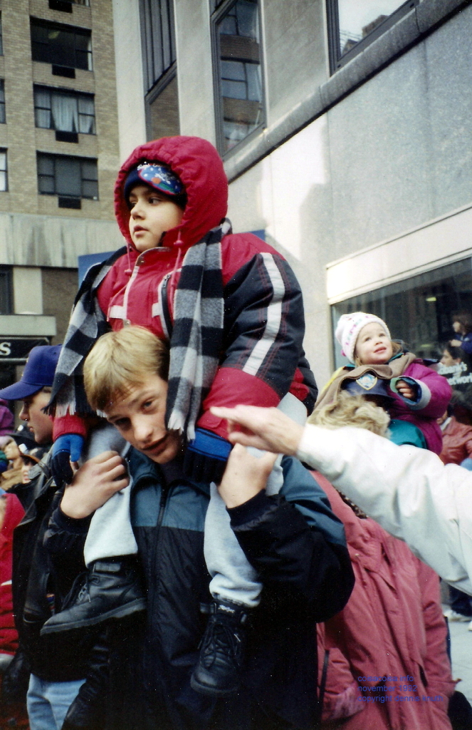 Nate hoists Raphael to see the Parade