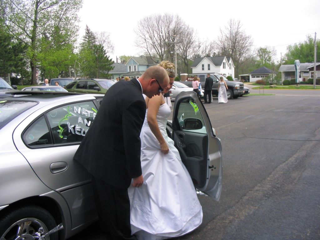 Groom helps with the brides dress