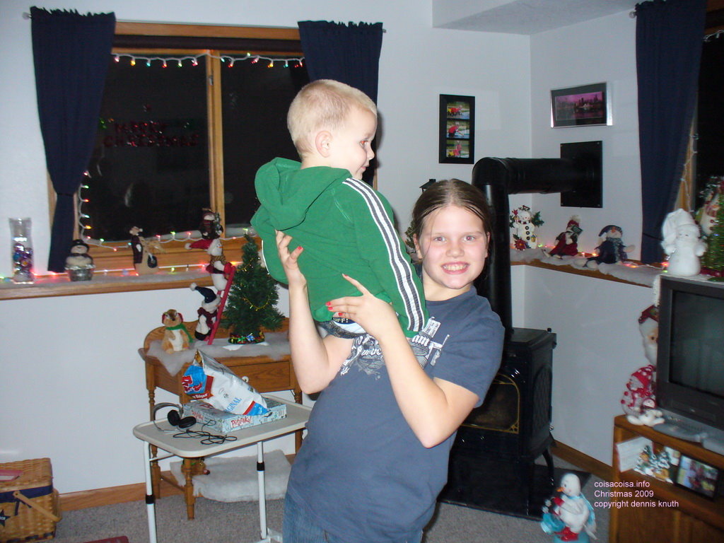 Kelsey holds up and presents her younger brother