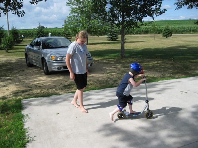 Kelsey chases Jared on a scooter